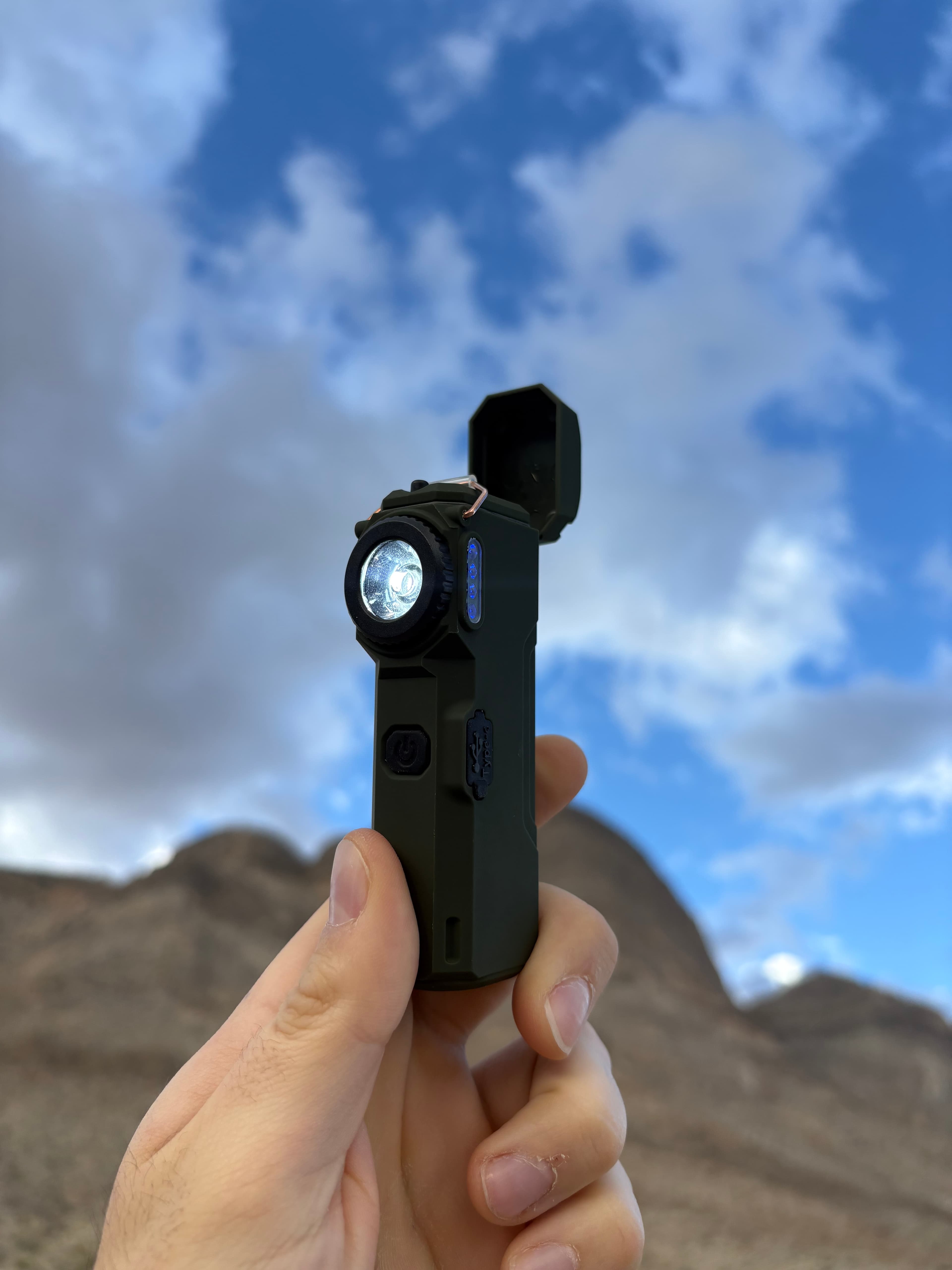 The Arc 80 held up against the sky with its flashlight on