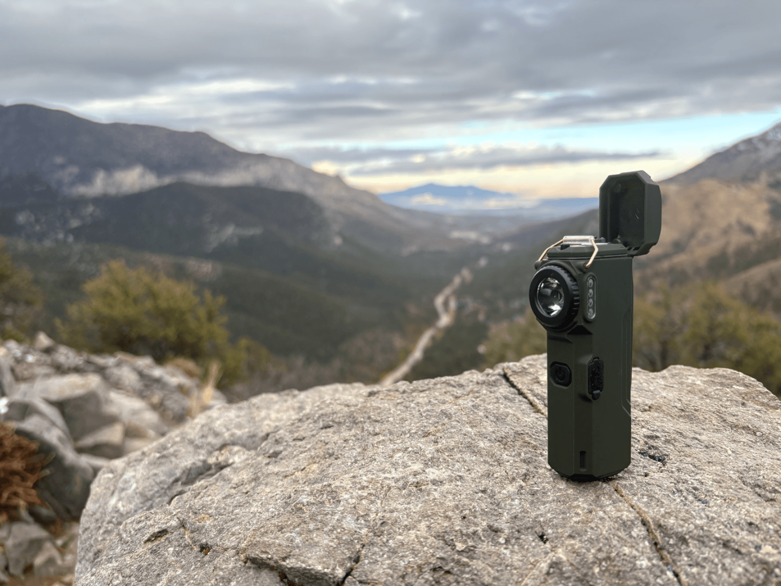 The Arc 80 standing on a boulder above a mountain valley, lid open